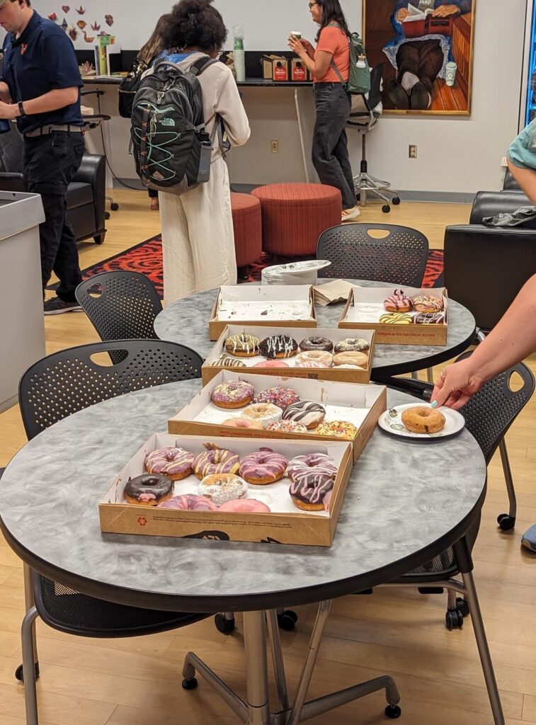 Boxes of donuts in in the library's myLab, with students in teh background.